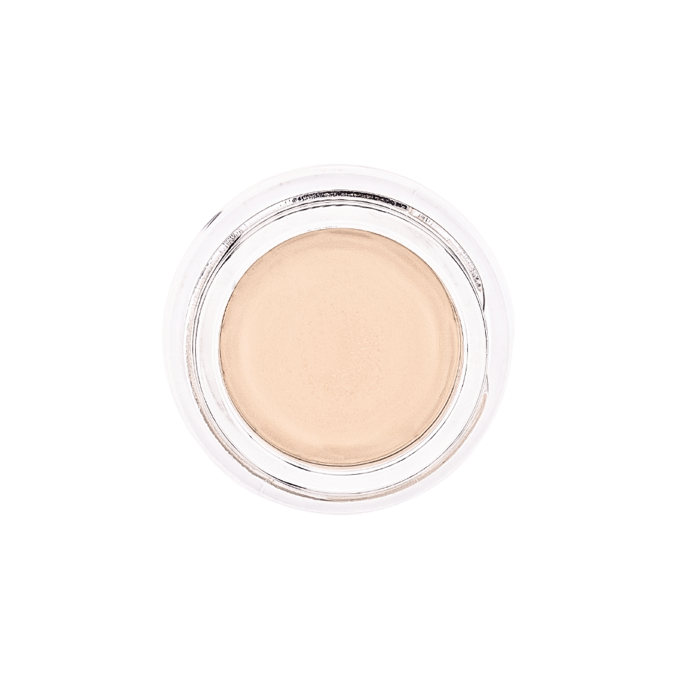 Straight-down view of 'Sea Shell' All-Over Brightening Concealer by Dr. Berrettini's Mendocino Minerals, porcelain shade, ivory with subtle peach undertones, in a glass bottom.